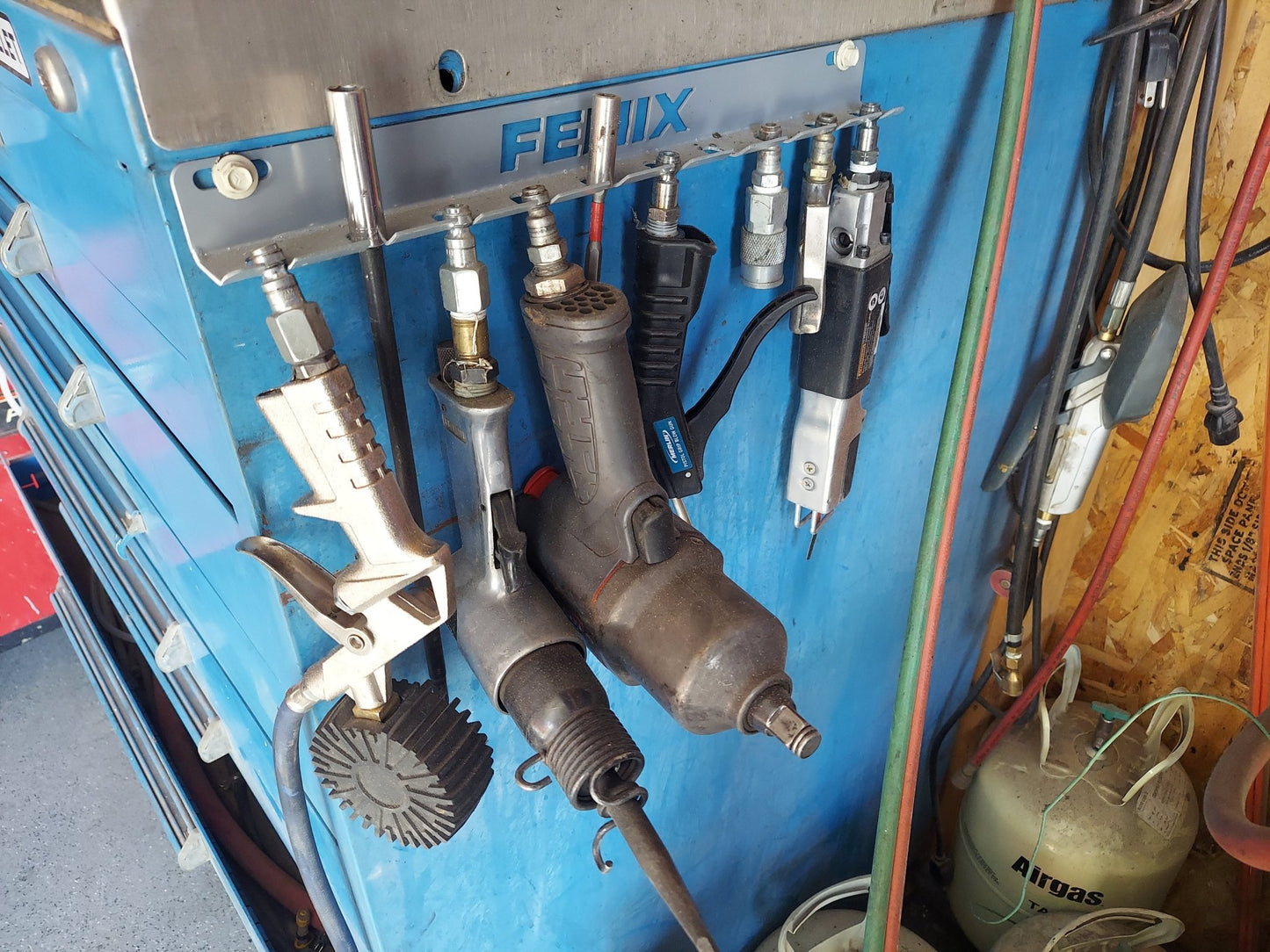 Wall-mounted air tool holder by Fenix Motorsport, durable steel design for organizing pneumatic tools in garages and workshops.